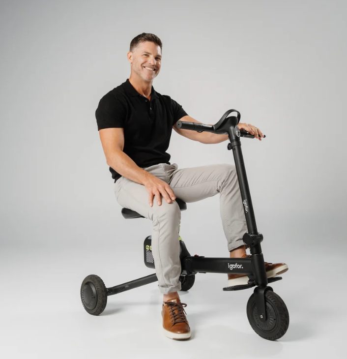Man seated on an Igofor folding mobility scooter by HATCHER TECH